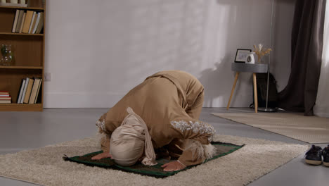 Mujer-Musulmana-Usando-Hijab-En-Casa-Orando-Arrodillada-Sobre-Una-Alfombra-De-Oración-4